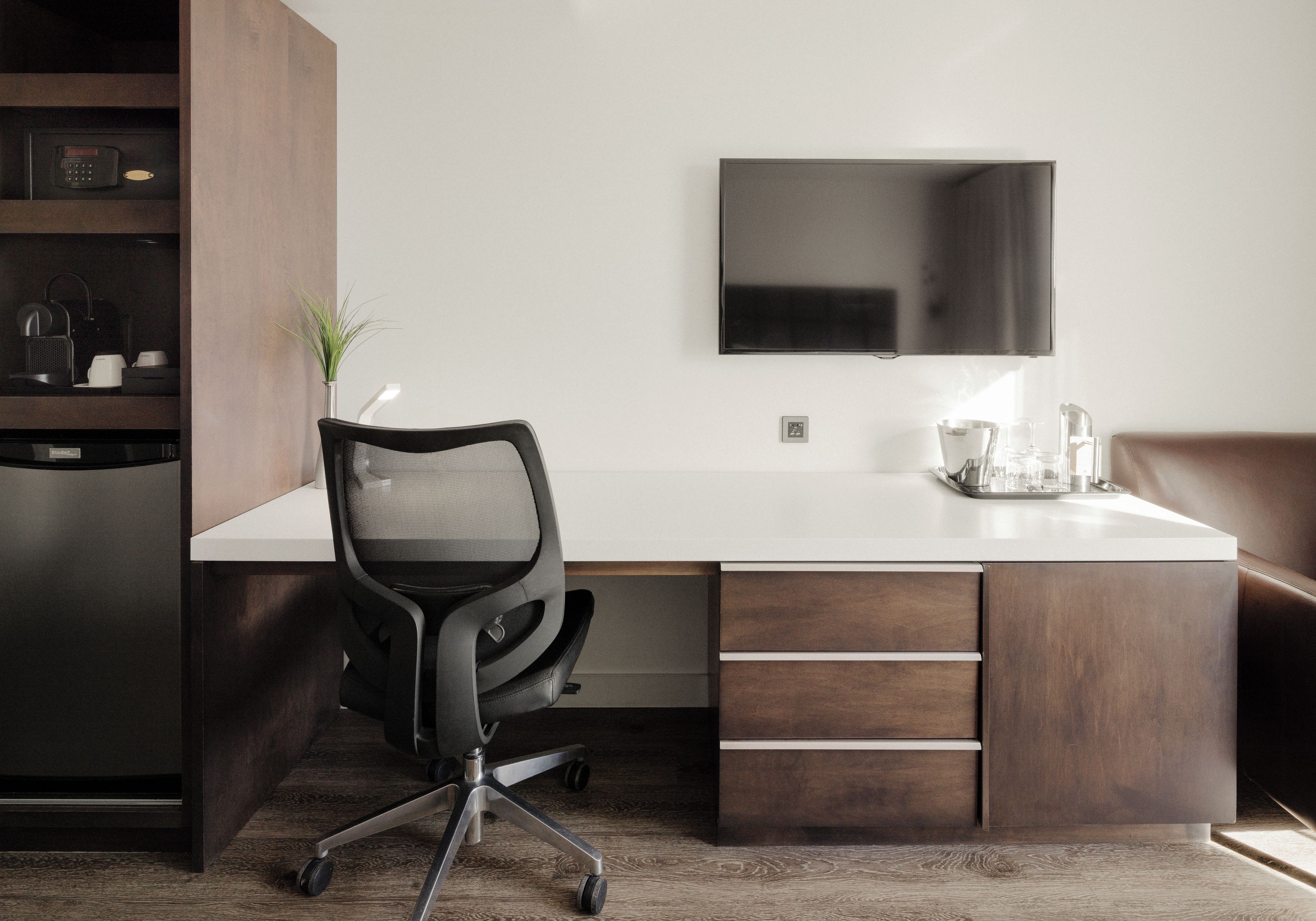 A modern kitchen with a built-in refrigerator, a coffee machine, and a plant on the counter.