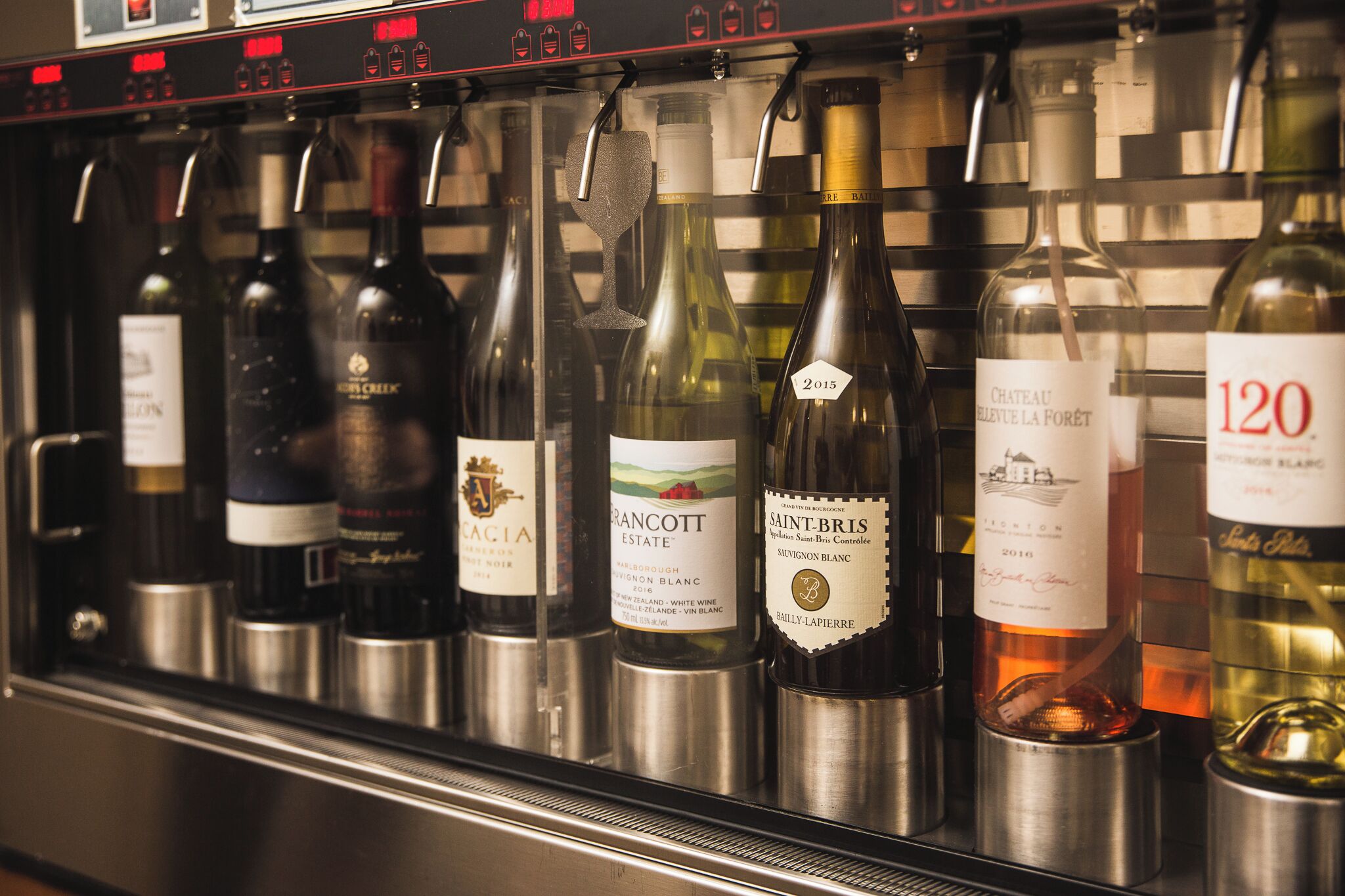A wine rack with various bottles of wine, including brands like Gracott Estate and Chateau La Forêt.