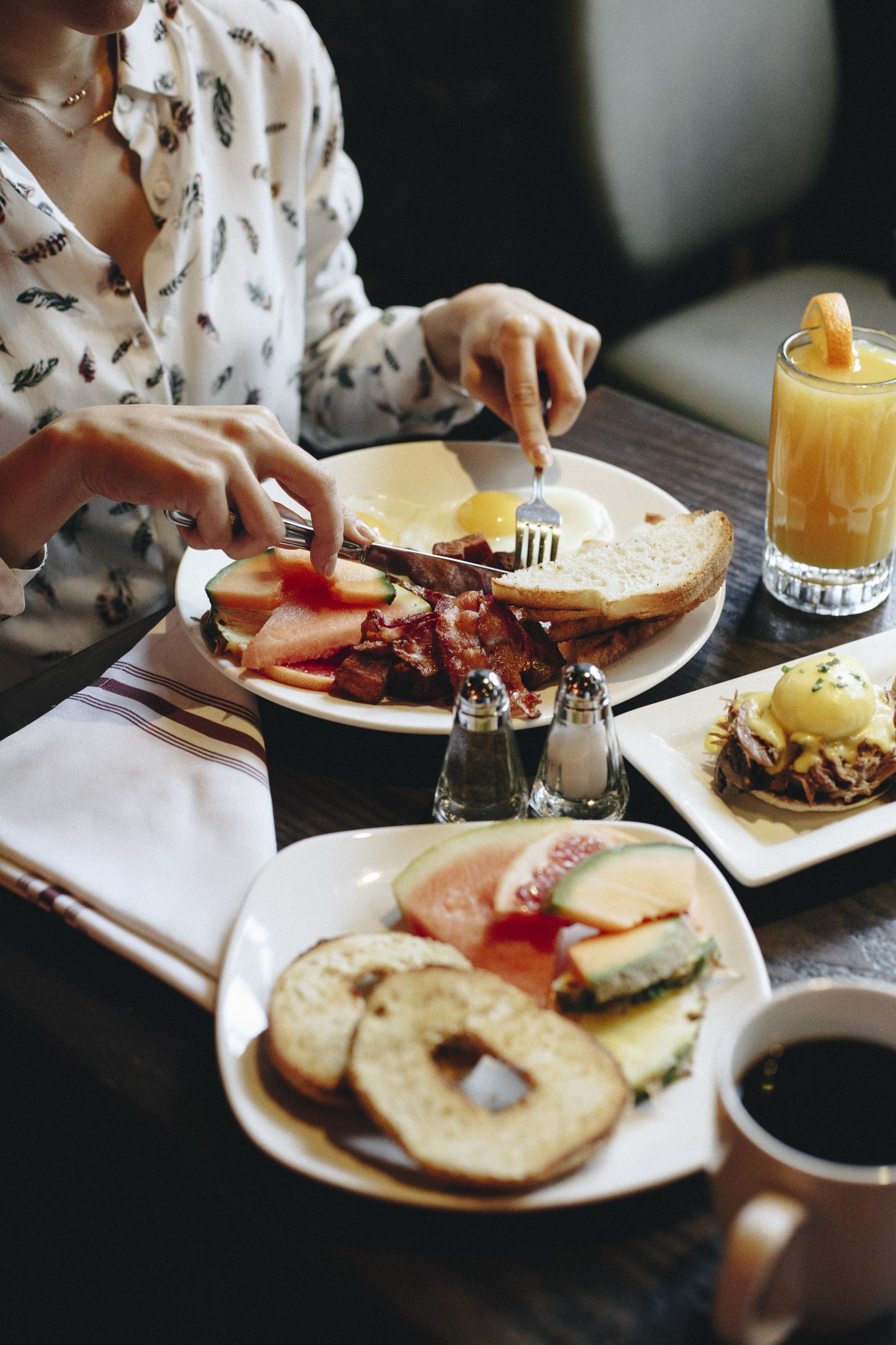 Una mesa de desayuno con diferentes platillos, incluyendo huevos, tocino y tostadas.