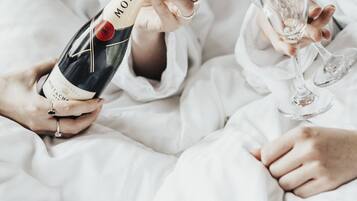 Una persona sosteniendo una botella de champán y una copa.