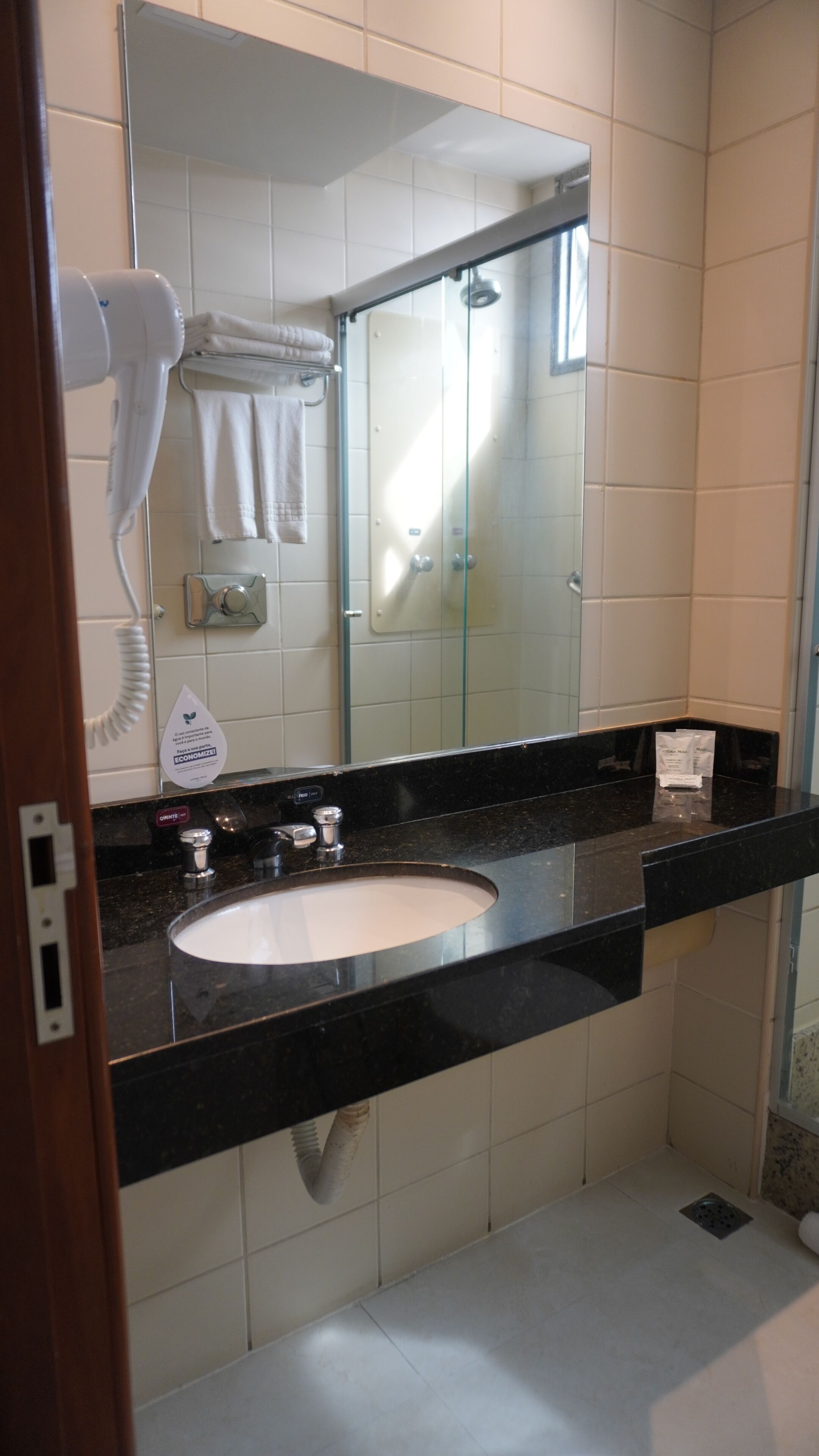 A bathroom with a sink, mirror, and towel rack.