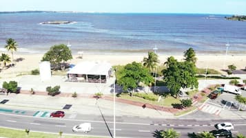 Una carretera costera con playa y palmeras.