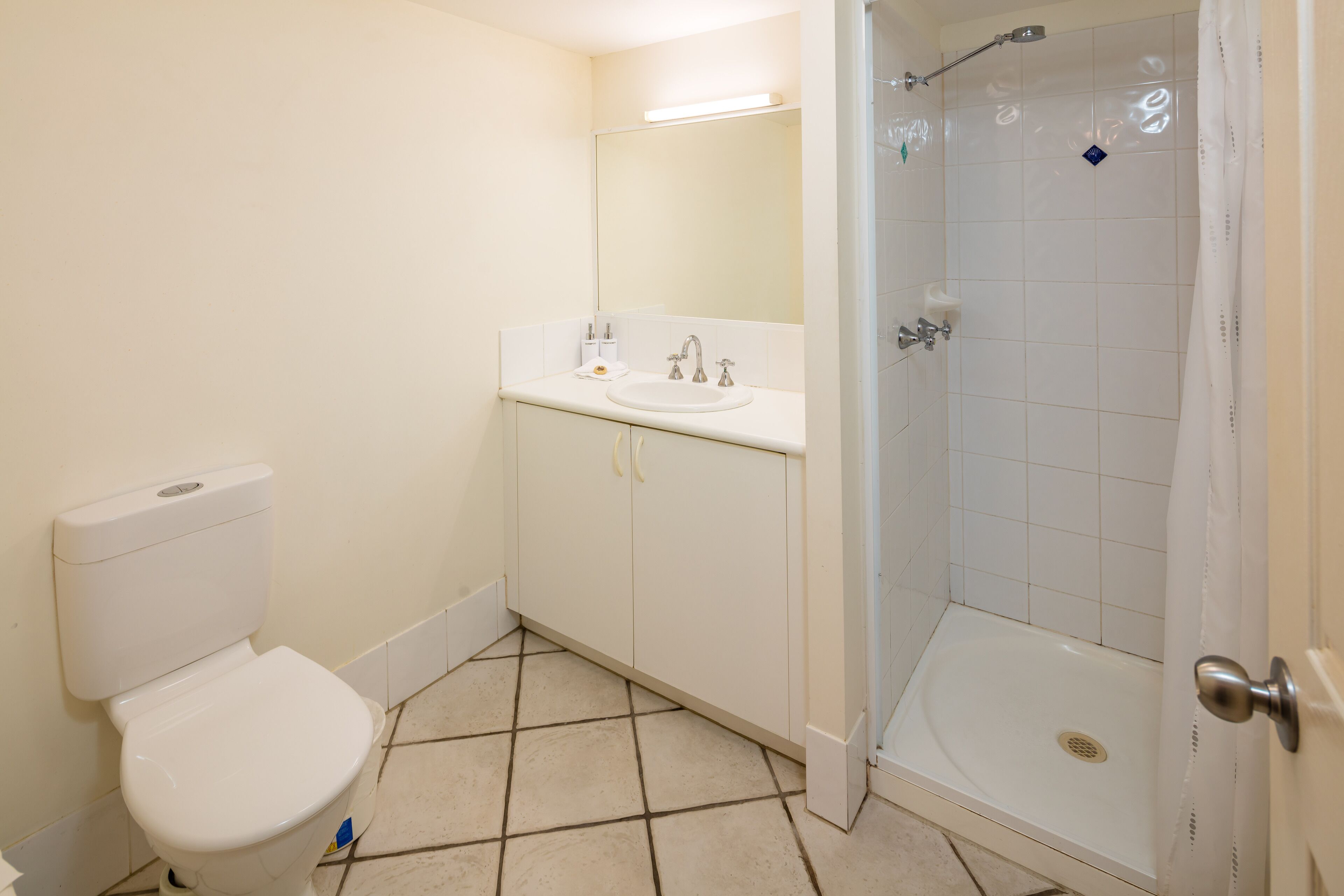 Une salle de bain équipée de toilettes, d’un lavabo et d’une douche.