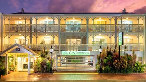 A multi-story hotel with a balcony on each floor, a sign for 'City Terraces' indicating short-term holiday apartments, and a small entrance building labeled '63'.