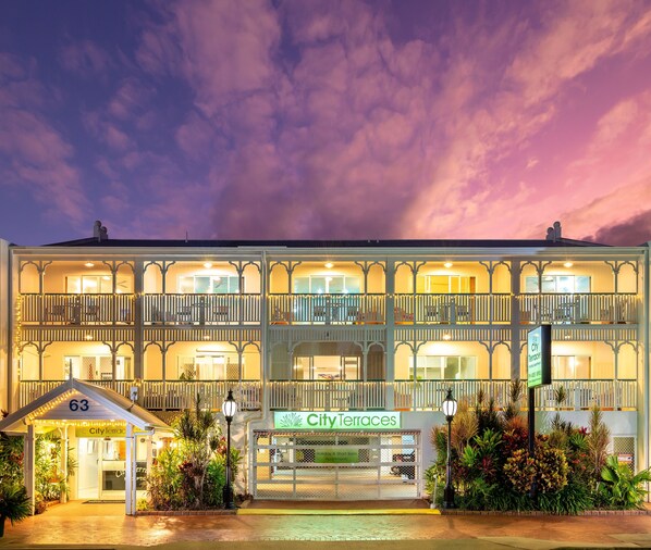 Ein mehrstöckiges Hotel mit einem Balkon an jeder Etage, eine Schilder 'City Terraces' für kurzzeitliche Ferienwohnungen und ein kleines Empfangsgebäude mit der Aufschrift '63'.