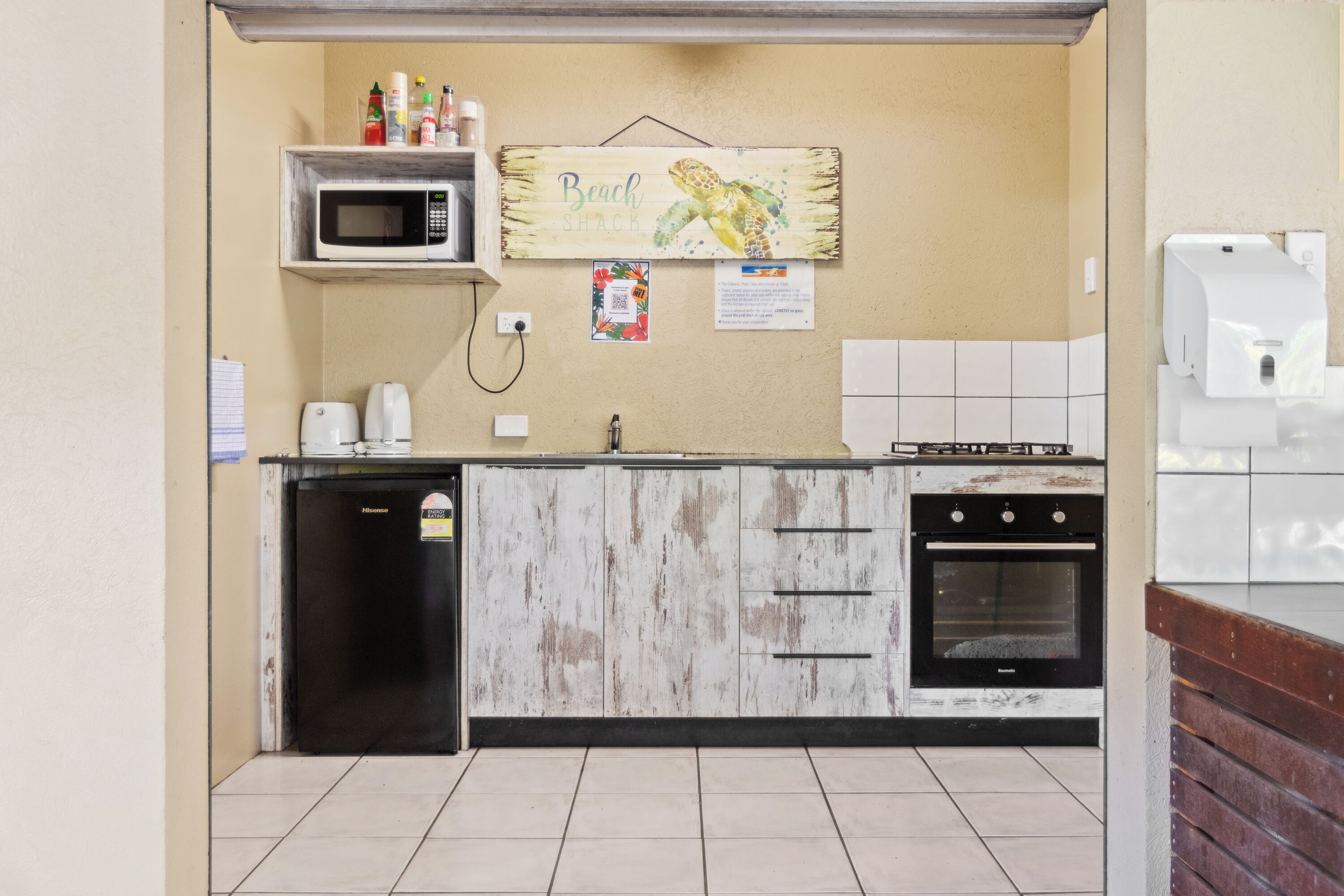 A kitchen with a microwave, a refrigerator, a sink, and a stove.