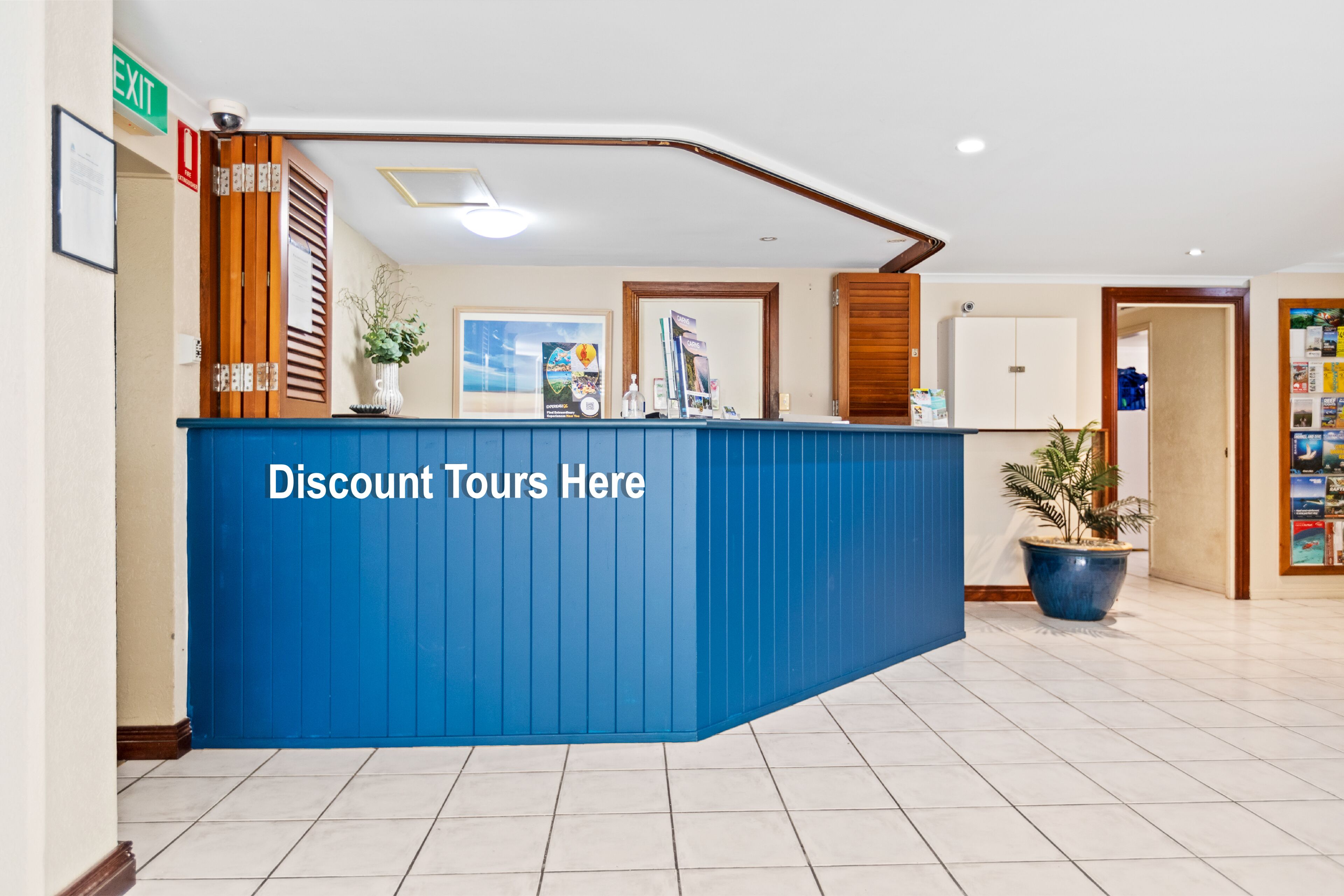 A reception area with a blue counter, framed pictures, and a potted plant.