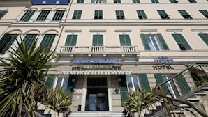 A hotel facade with a sign reading 'MEDITERRANEE HOTEL' and a staircase leading to the entrance.