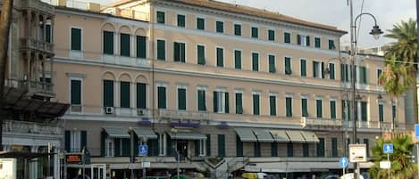 A multi-story hotel with a classic architectural style, featuring balconies and a central courtyard.