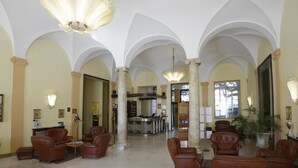 Un vestíbulo amplio con techos abovedados, asientos de cuero y una zona de recepción.