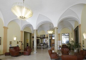 Um hall amplo com tetos abobadados, assentos de couro e uma área de recepção.