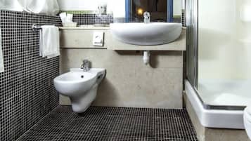 Un baño con bidé, lavamanos y ducha.