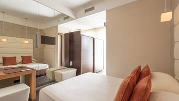 Quarto de hotel moderno com uma cama grande, uma escrivaninha, uma cadeira e uma televisão.