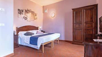Une chambre à coucher avec un lit, une table de chevet, une lampe et une armoire.