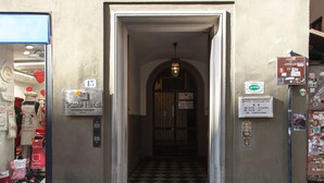 A hotel entrance with a checkered floor, a visible elevator, and a sign indicating the hotel name and amenities. - Hotel Costantini (Florence)