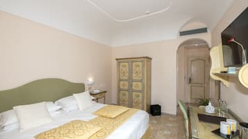 Habitación de hotel con cama, cómoda, espejo y puerta que da a otra habitación.