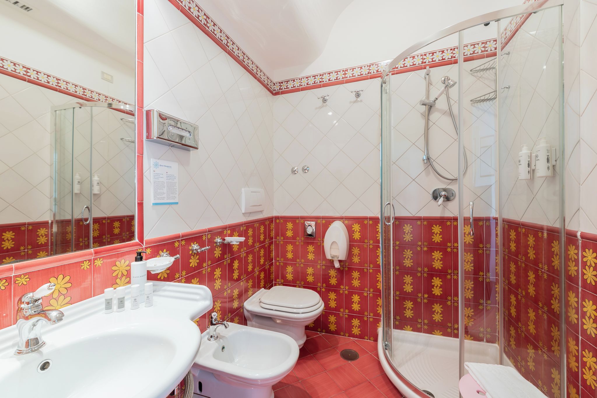 Un baño con ducha, dos lavamanos, inodoro y bidé.