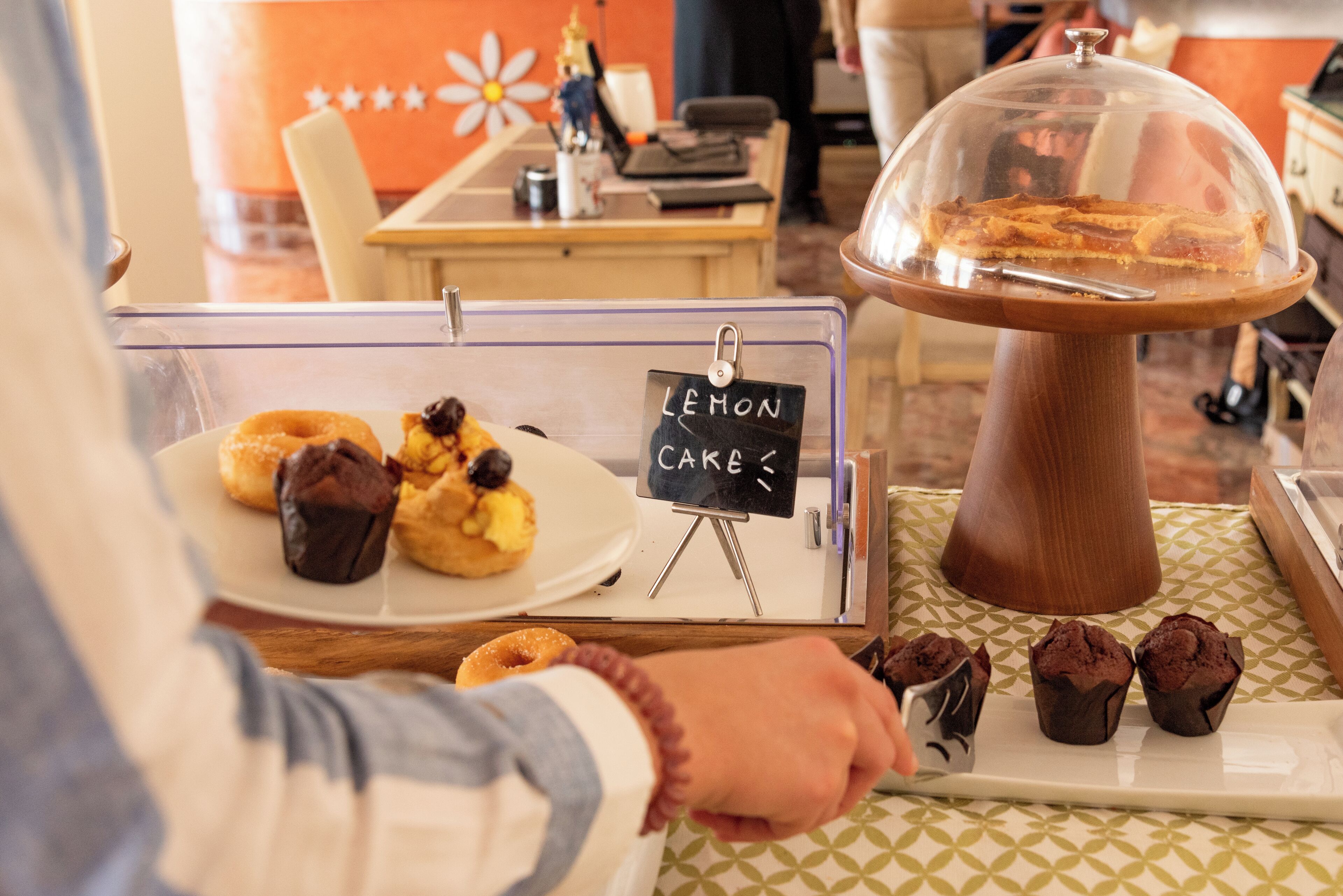 Vitrine de pastelaria com bolos de limão e muffins.