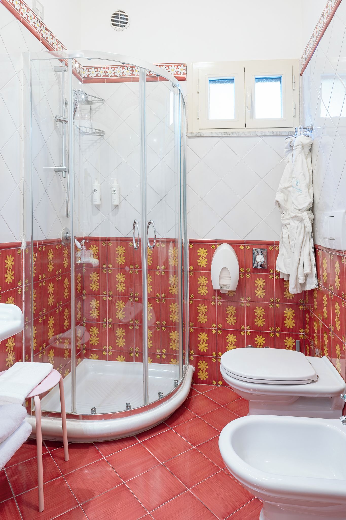 Un baño con ducha de vidrio, inodoro y bidé.