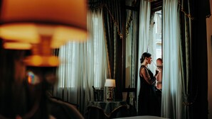 Une chambre d’hôtel avec un lit, une table avec une lampe et des rideaux.