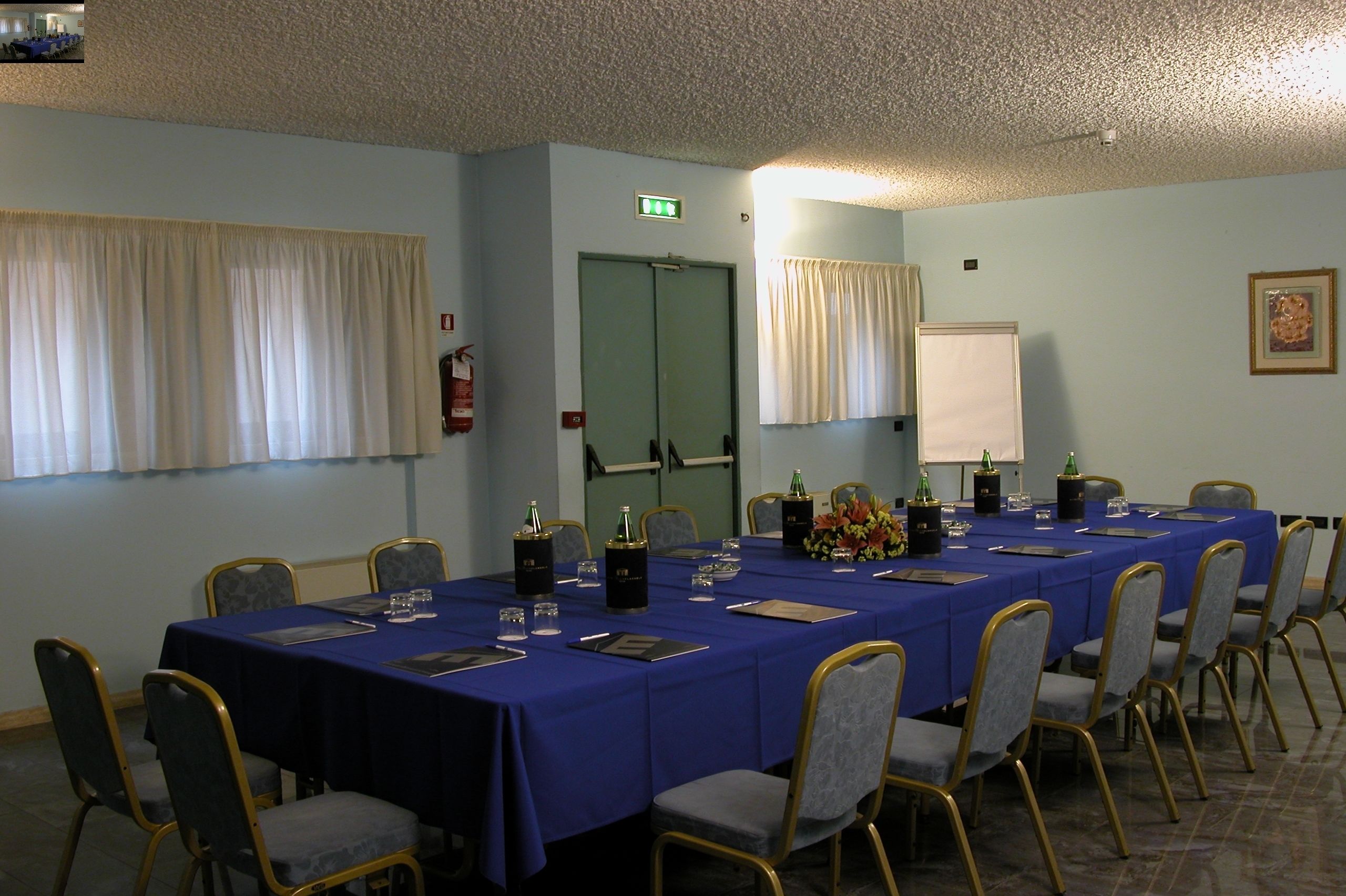 A conference room with a long table, chairs, and a door.