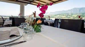A table set for dining with a view of mountains in the background. - Hotel Michelangelo Palace (Terni)