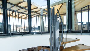 A modern interior with a glass ceiling, wooden tables, and white chairs arranged for dining. - Hotel Michelangelo Palace (Terni)