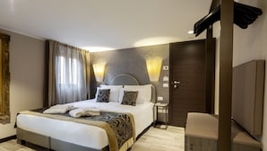 Ein modernes Hotelzimmer mit einem großen Bett, Nachttischen, einem Kleiderschrank und Wandleuchten.
