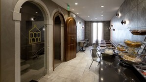 Eine moderne Hotelhalle mit einer Selbstbedienungsbereich, Marmorböden und einer Glastrennwand mit einer Hängeleuchte.