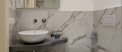 A modern bathroom with a white sink, a toilet, and a mirror above the sink.