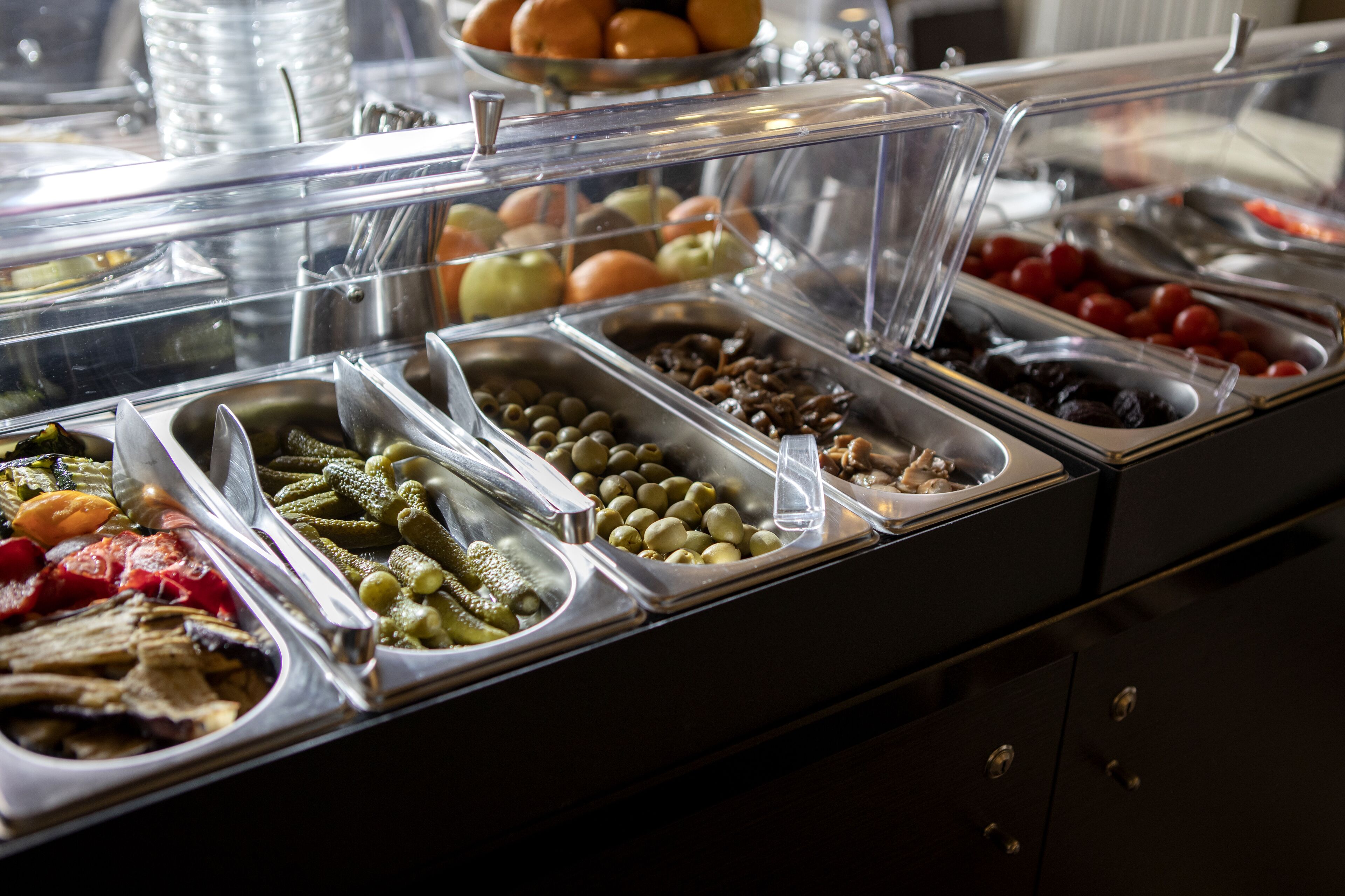 Un buffet proposant une variété de plats, notamment des fruits, des légumes et des fruits à coque.