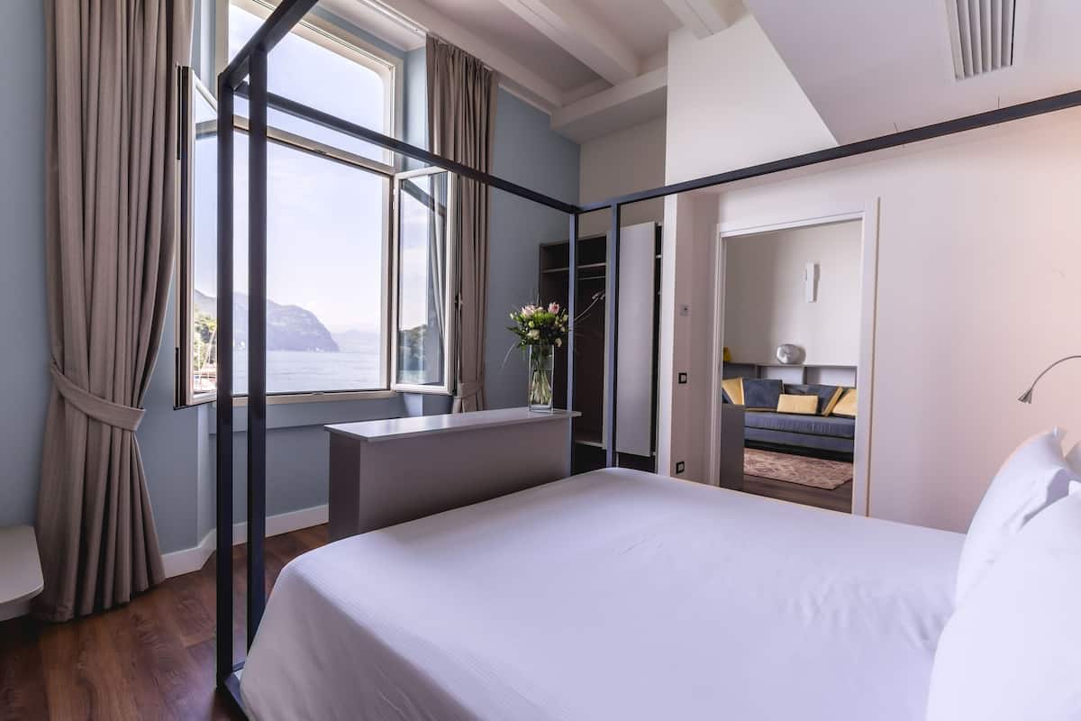 Une chambre d’hôtel moderne avec un grand lit, un bureau et une vue sur la mer.