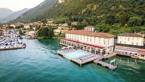 Un hôtel situé au bord de l’eau, doté d’une piscine, d’un quai et entouré d’autres bâtiments.