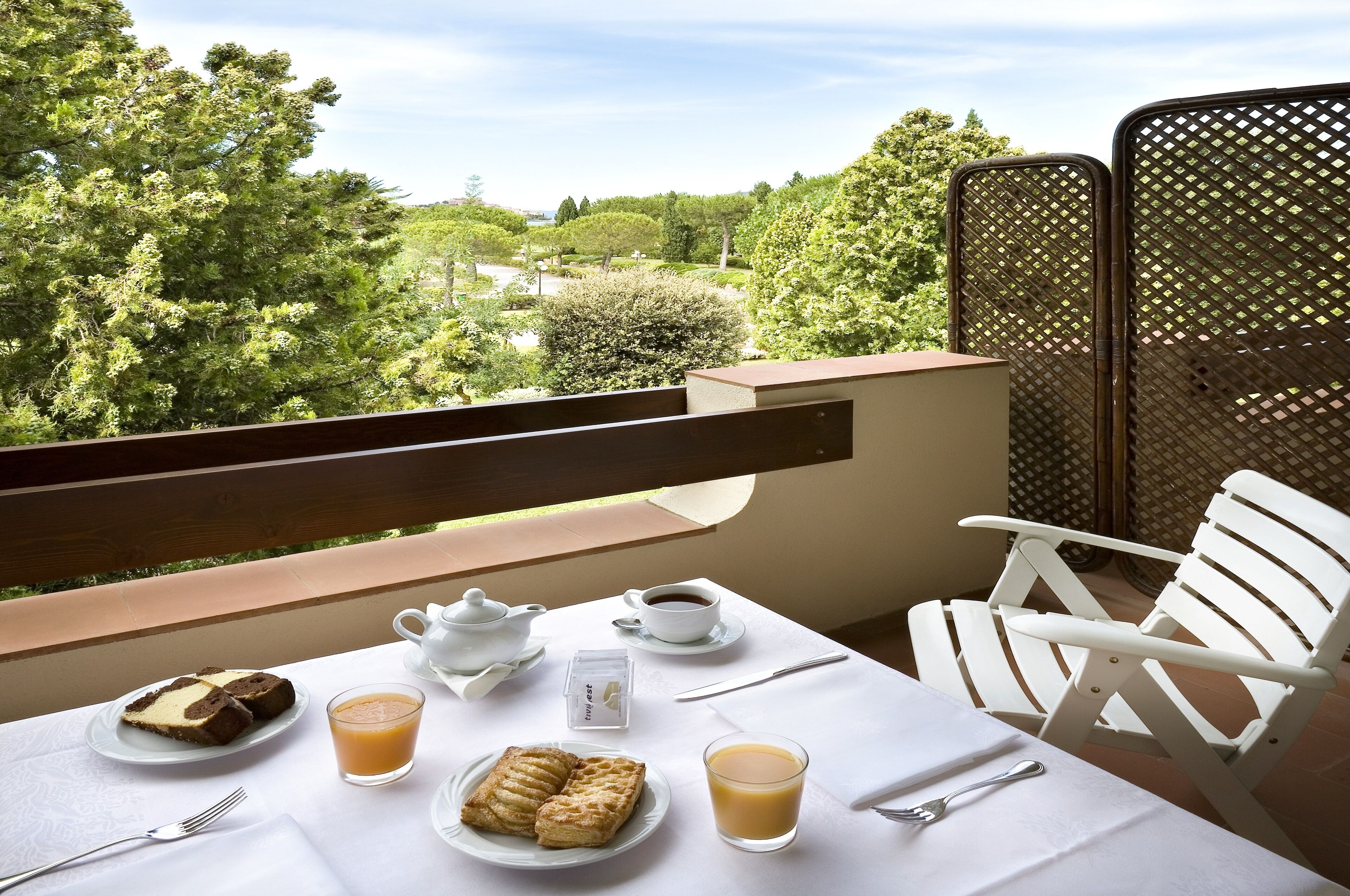 Una mesa con alimentos para el desayuno y vistas a un exuberante jardín.