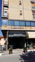 Un hotel llamado 'Clarici' con una fachada moderna, ventanas amplias y una entrada visible.