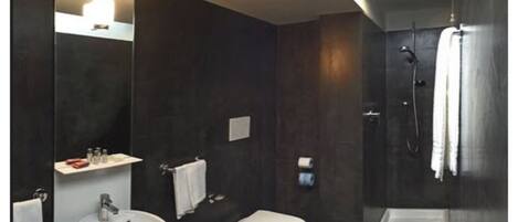 Un baño moderno con lavamanos, inodoro y ducha.