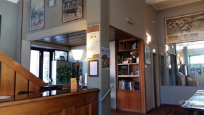 Una biblioteca con estanterías, una escalera y un cartel en la pared.