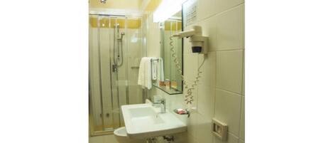A bathroom with a glass-enclosed shower, a sink, and a toilet.