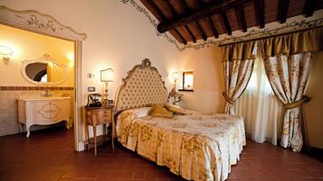 A bedroom with a large bed, a vanity with a mirror, and a nightstand.
