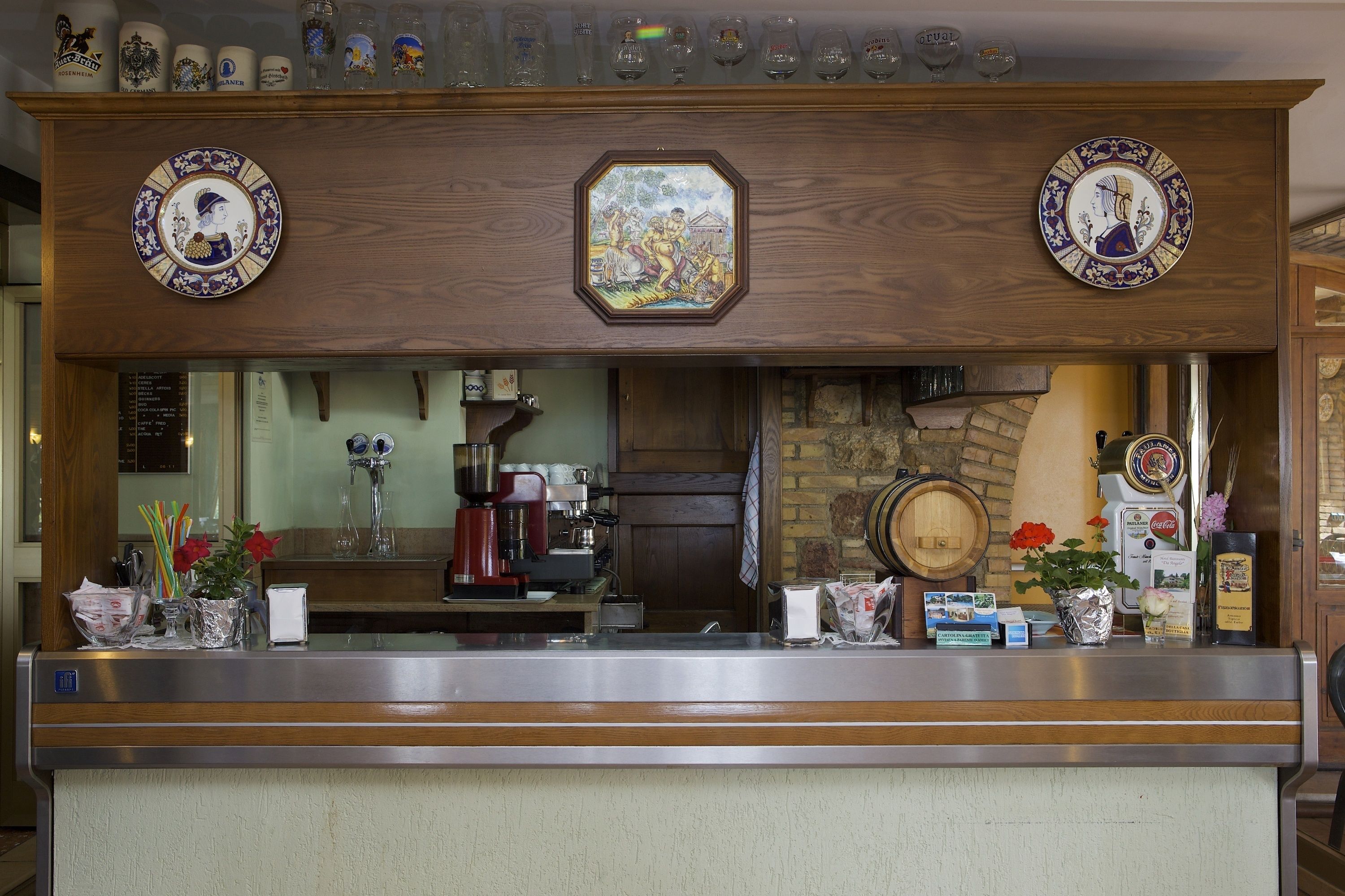 Een bar met een houten toonbank, koffieapparaten en decoratieve borden.