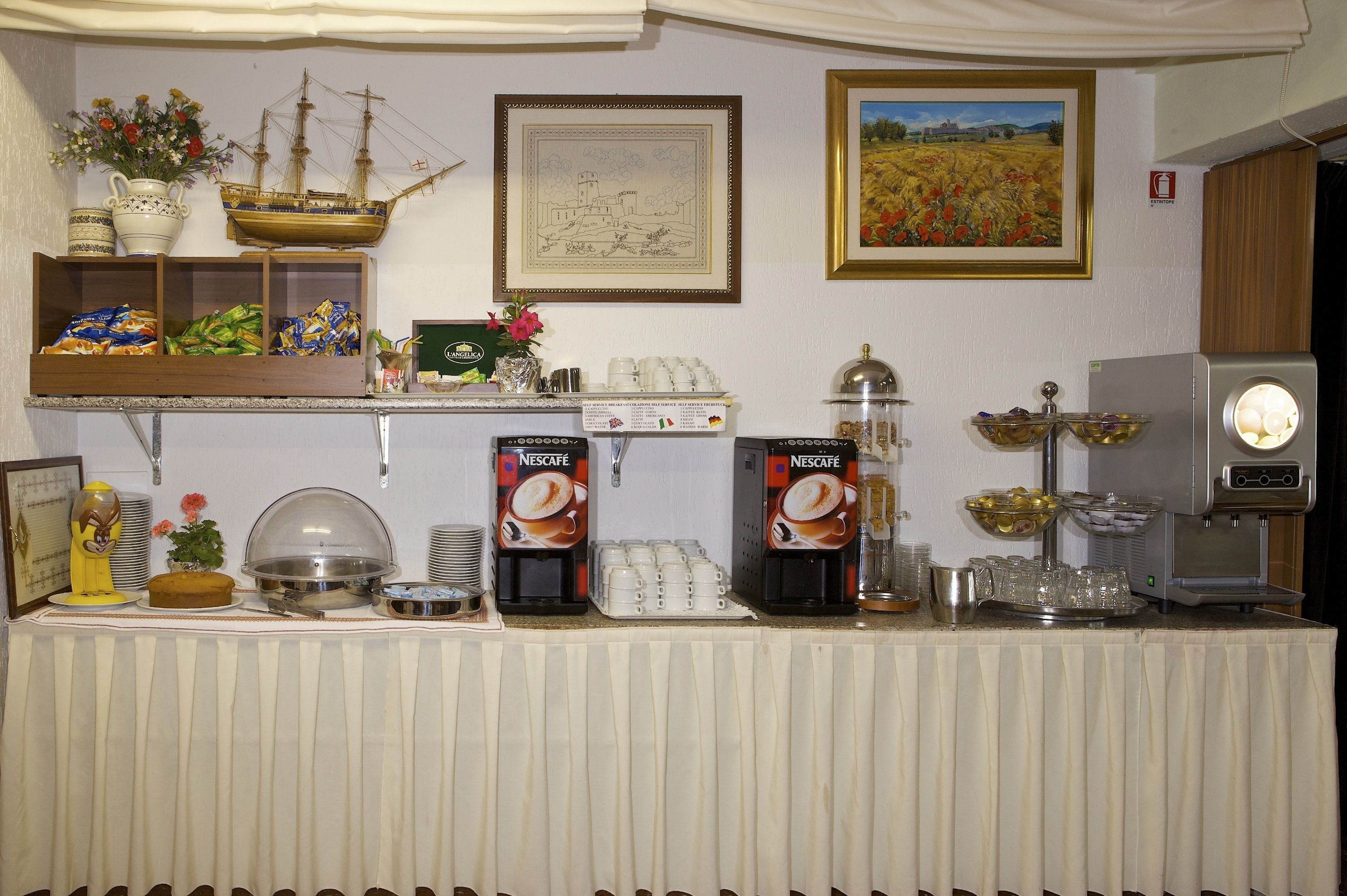 A buffet setup with coffee machines, a ship model, and decorative items.