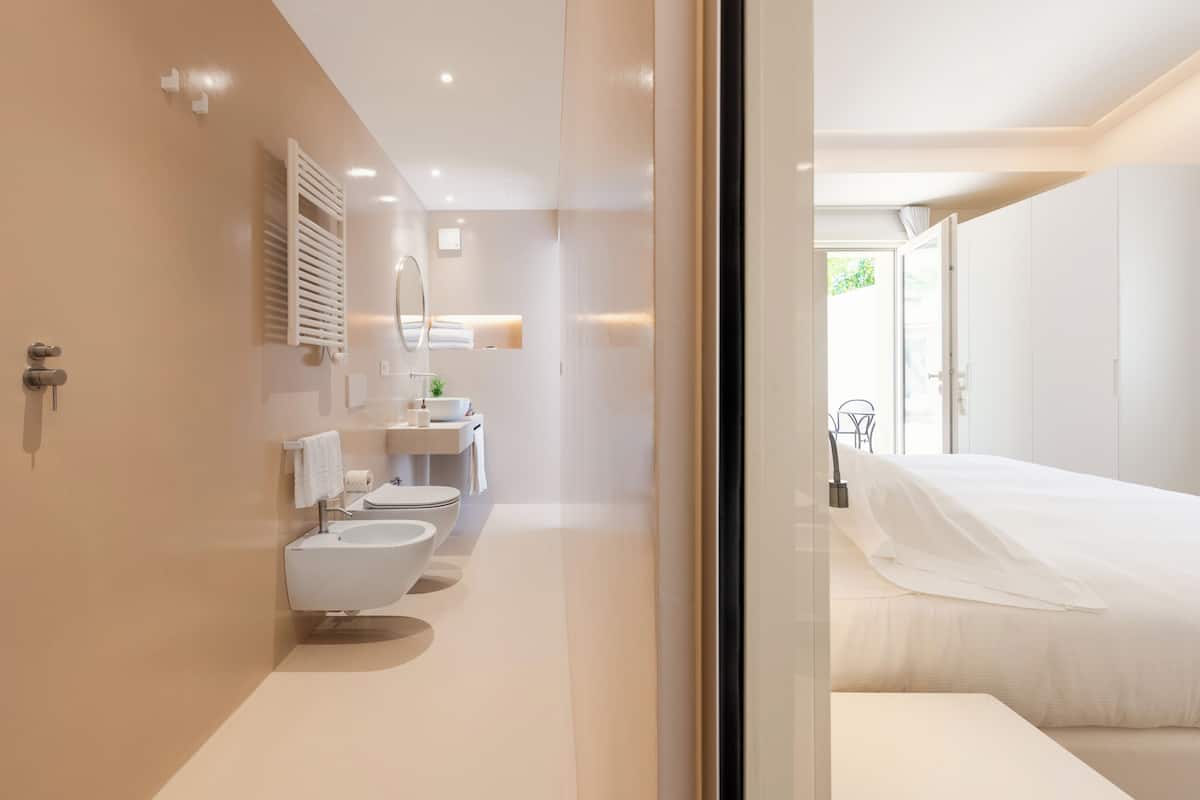 Un baño moderno con inodoro, lavabo y espejo.