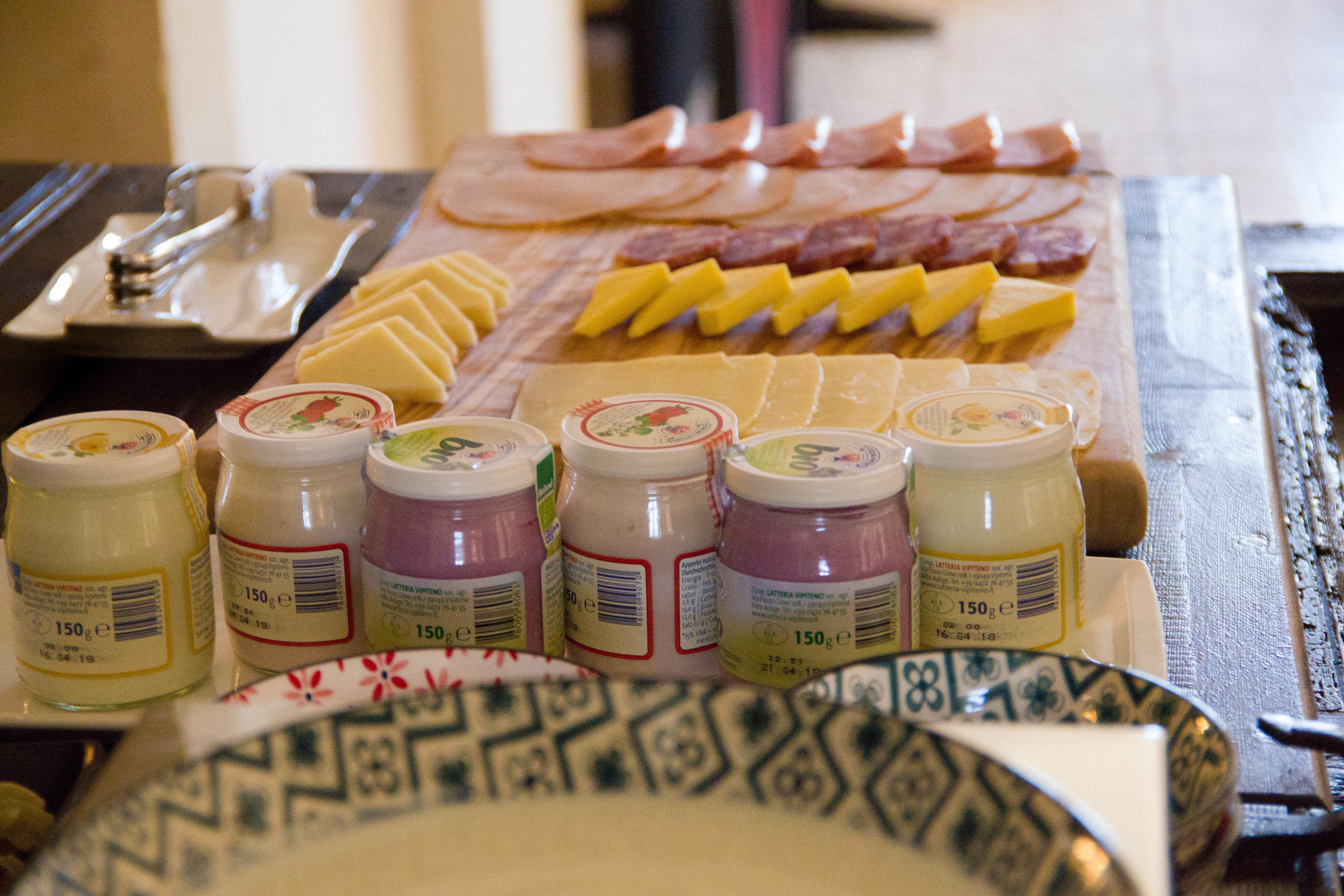 Une planche de charcuterie avec différentes sortes de viandes, de fromages et de condiments.