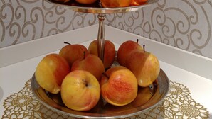 A three-tiered fruit stand with oranges and apples. - Hotel Vittoria & Orlandini (Genoa)