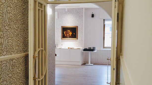 An open doorway leading to a room with a marble floor, a patterned wall, and a framed artwork on the wall. - Hotel Vittoria & Orlandini (Genoa)