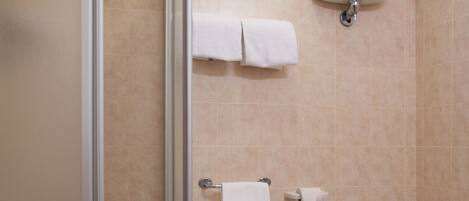 Un baño con cabina de ducha de vidrio, un bidé y un inodoro.