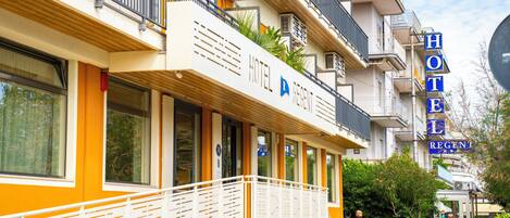 A hotel with a white facade, balconies, and a sign reading "HOTEL REGENT".