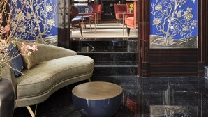 A modern interior with a sofa, a round table, and a dining area with red chairs. - Vista Verona (Verona)