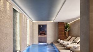 A spa area with a blue pool, lounge chairs, and a night sky mural. - Vista Verona (Verona)