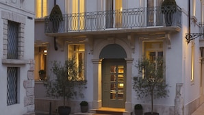 A building with the name "VISTA" and a five-star rating. It features a grand entrance with a door, steps, and potted plants. - Vista Verona (Verona)